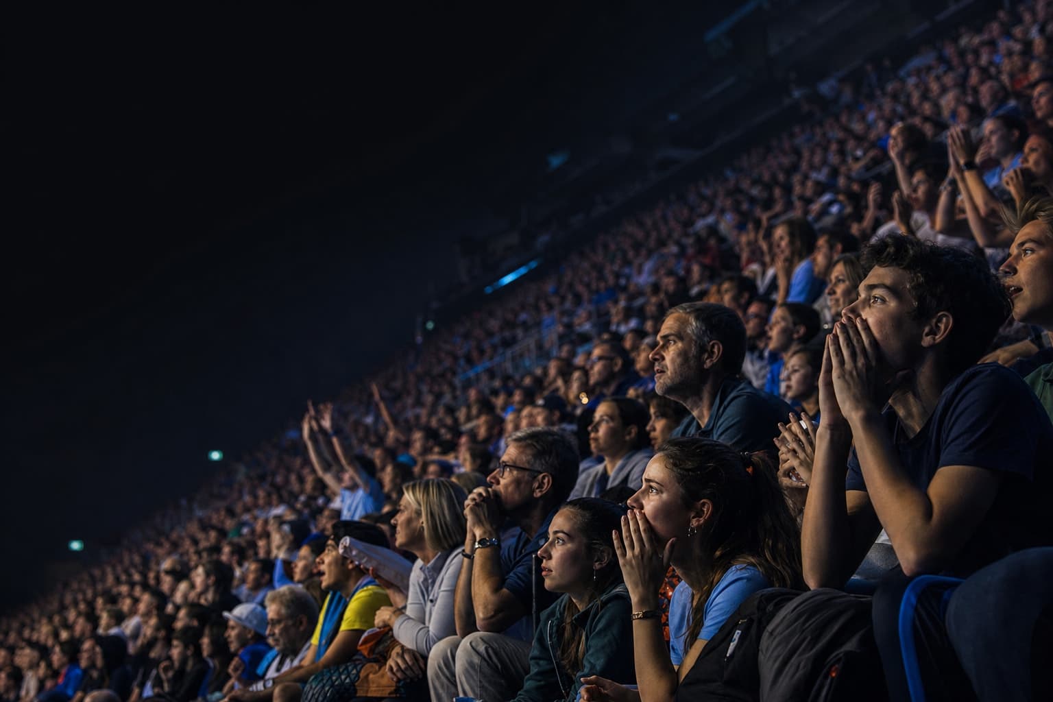 Arena crowd — tense anticipation under cool blue stadium light